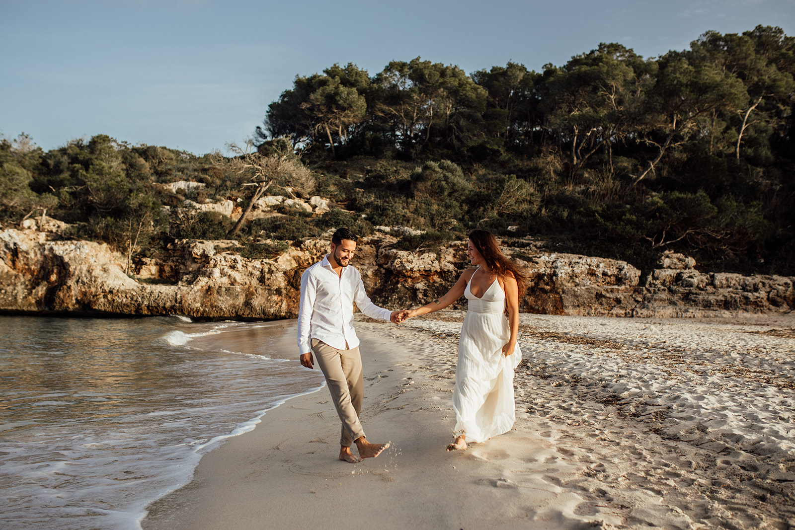 Paarfotoshooting auf Mallorca als After Wedding Shooting in Playa de S'Amarador. Paar läuft am Strand entlang 