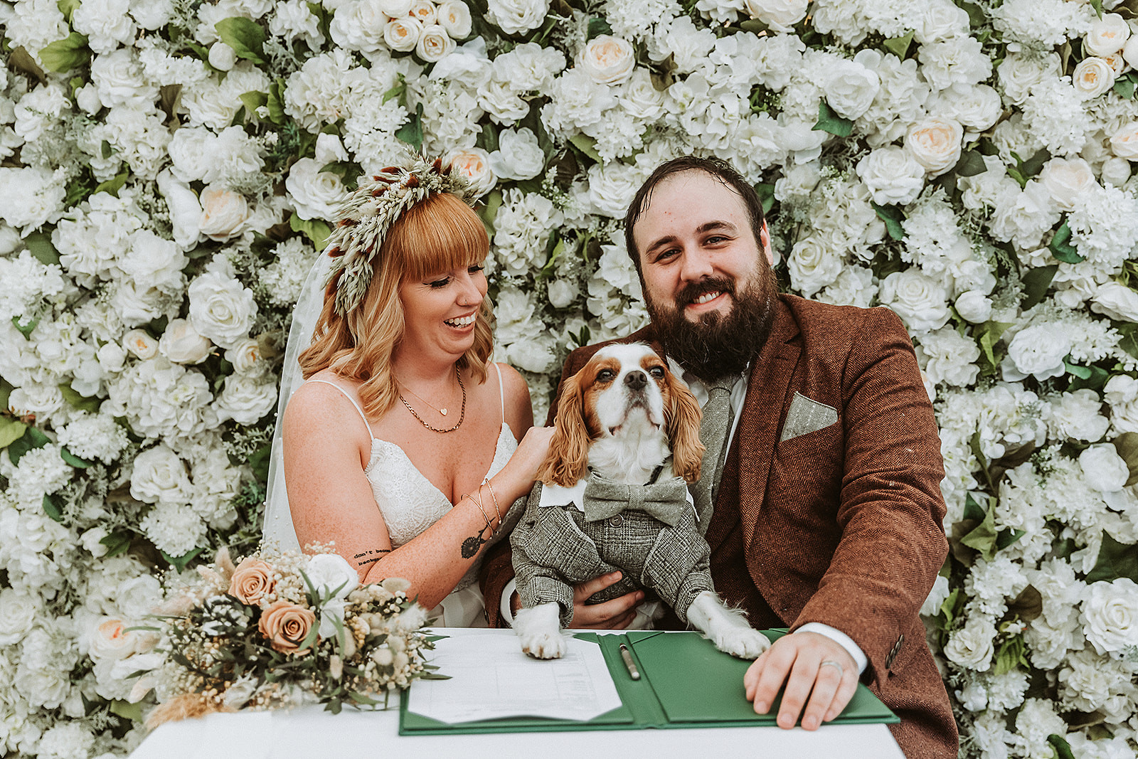 bride and groom and their dog signing their certificate at the waterside venue Rickmansworth wedding photographer 