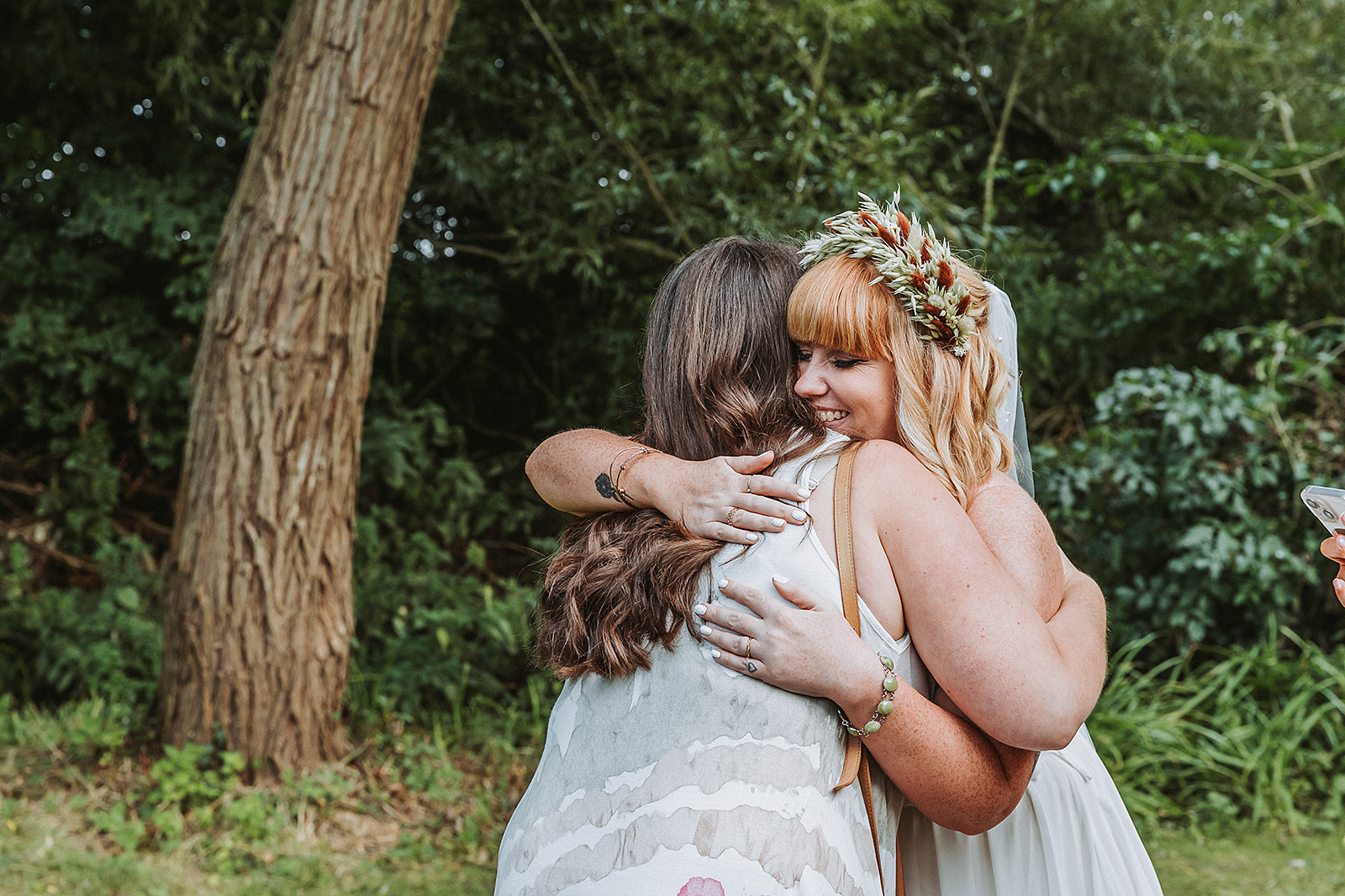 bride and friend hugging at wedding in the waterside venue rickmansworth wedding photographer hertfordshire