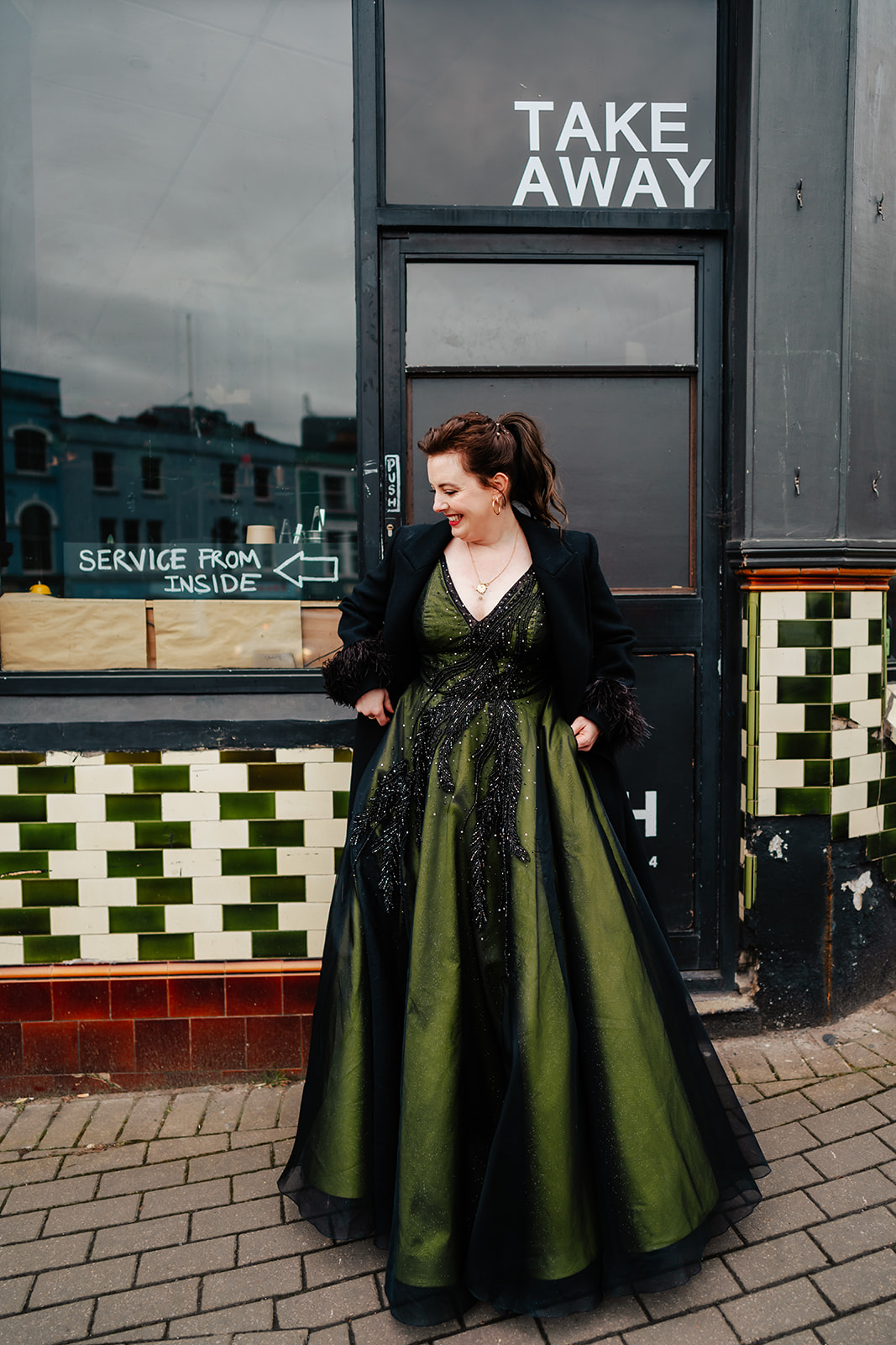 bride in green dress in front of shop in Bristol
