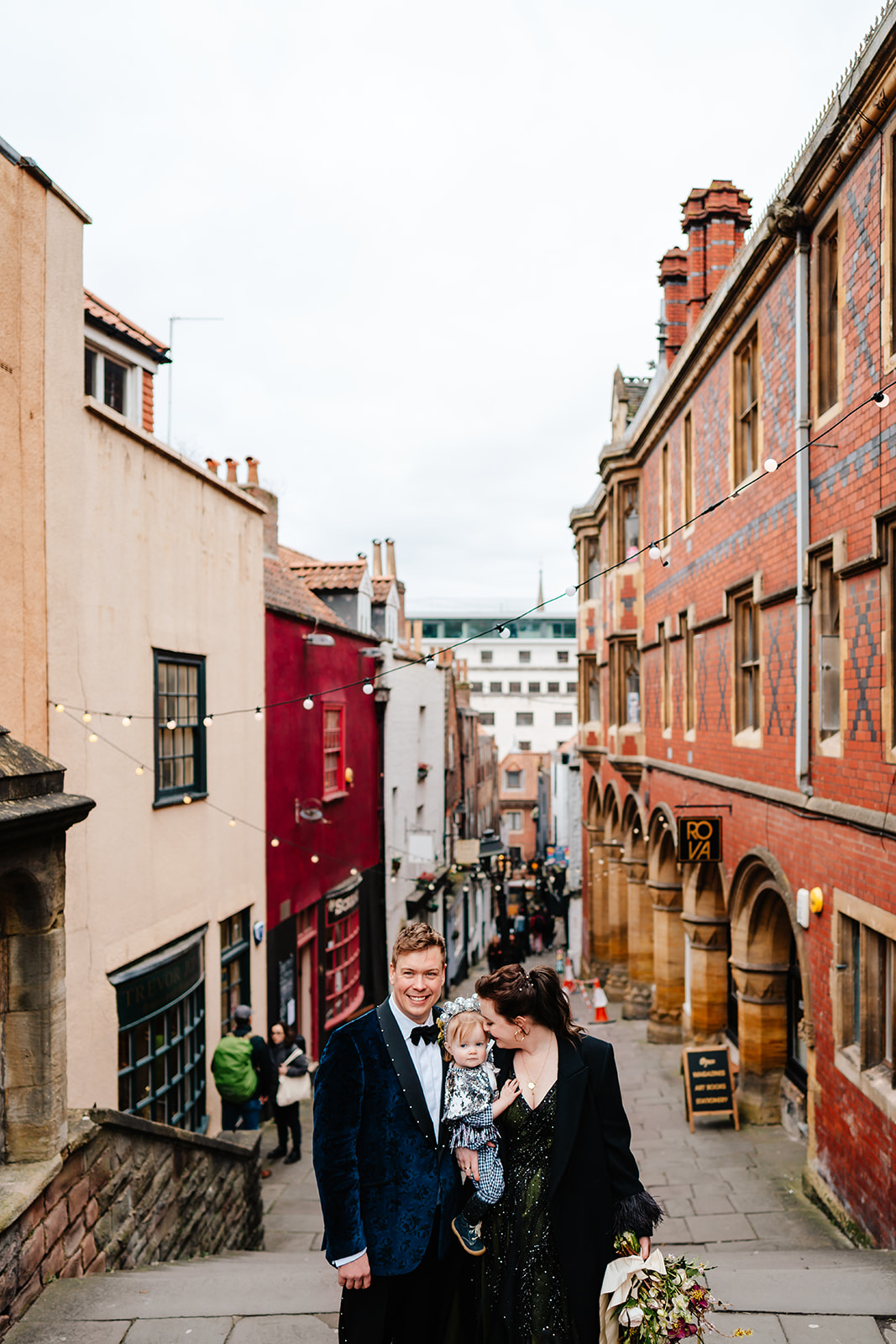 wedding couple & their child cuddling on Christmas Steps in Bristol City Centre