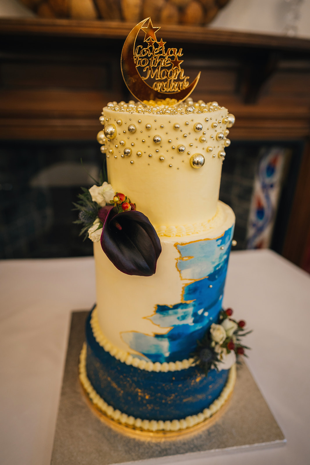 three tiered wedding cake with blue and ivory icing