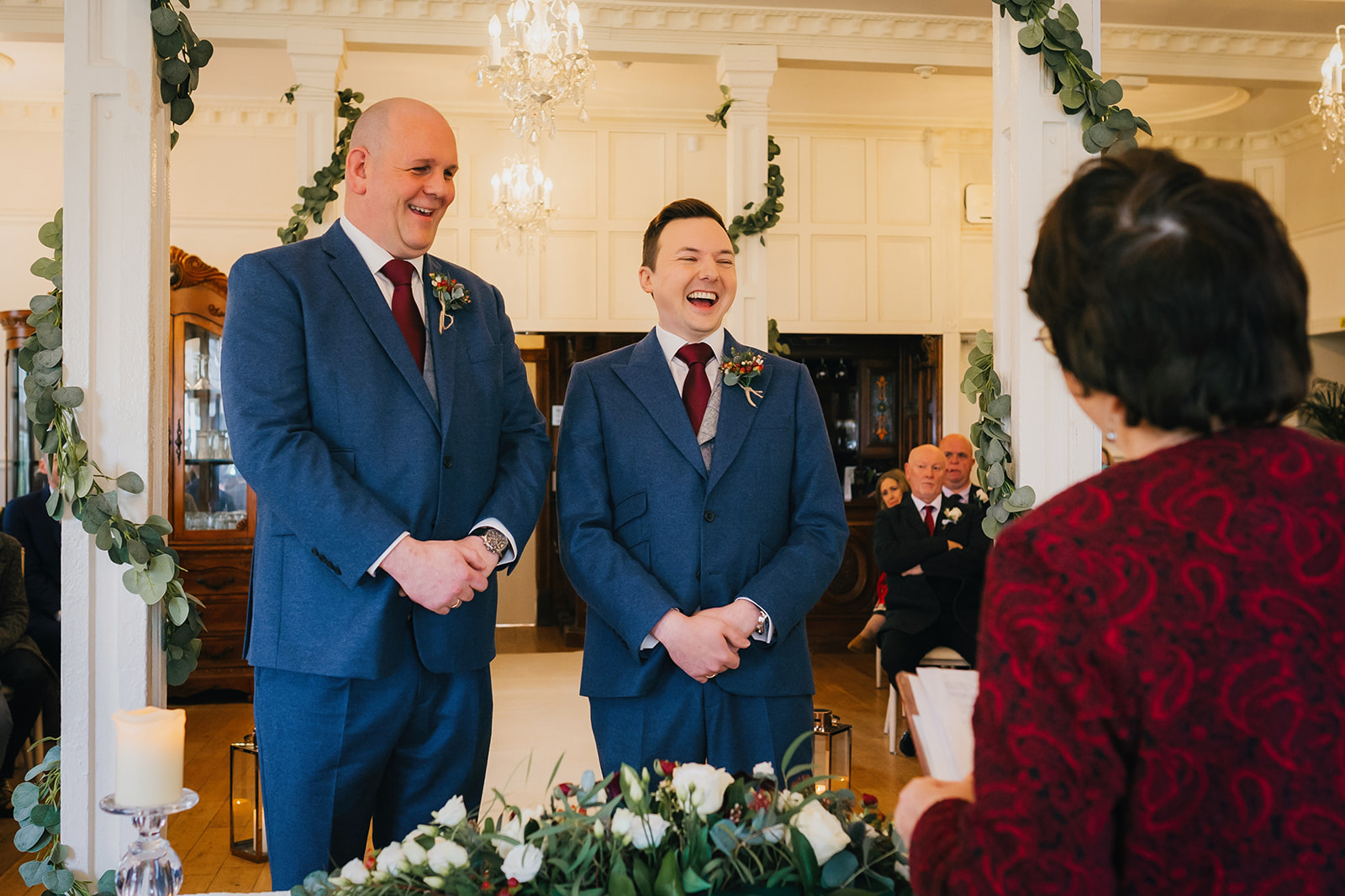 two grooms laugh at their celebrant during their wedding ceremony