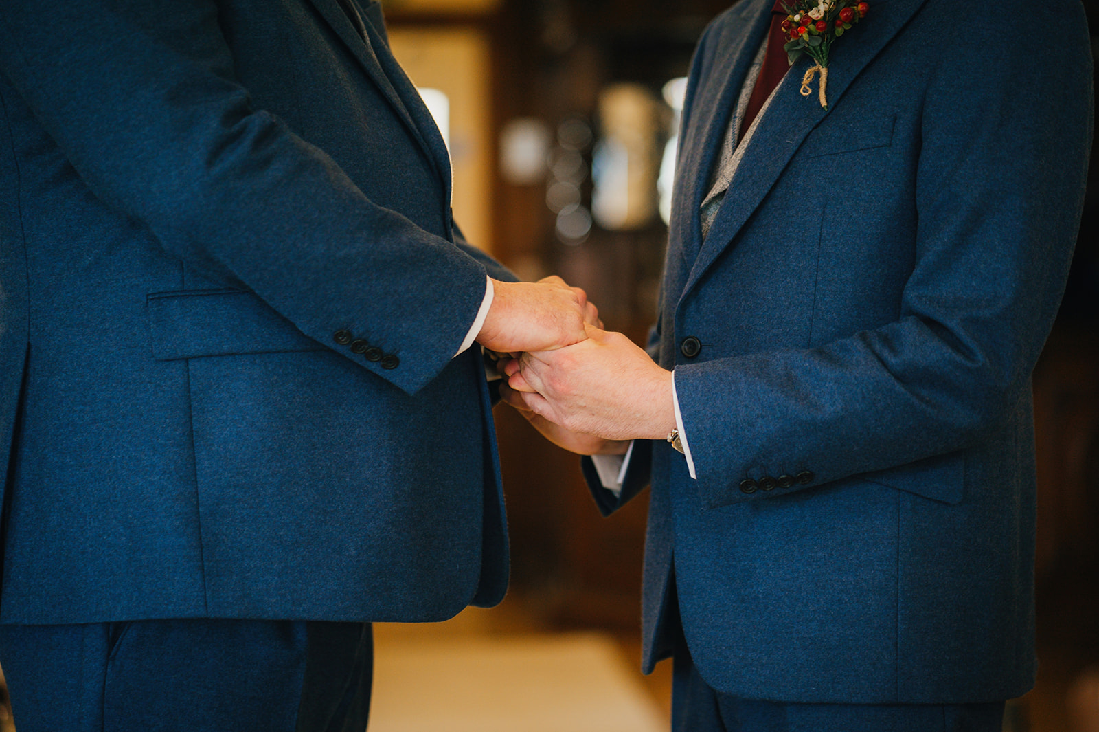 close-up of the grooms holding hands
