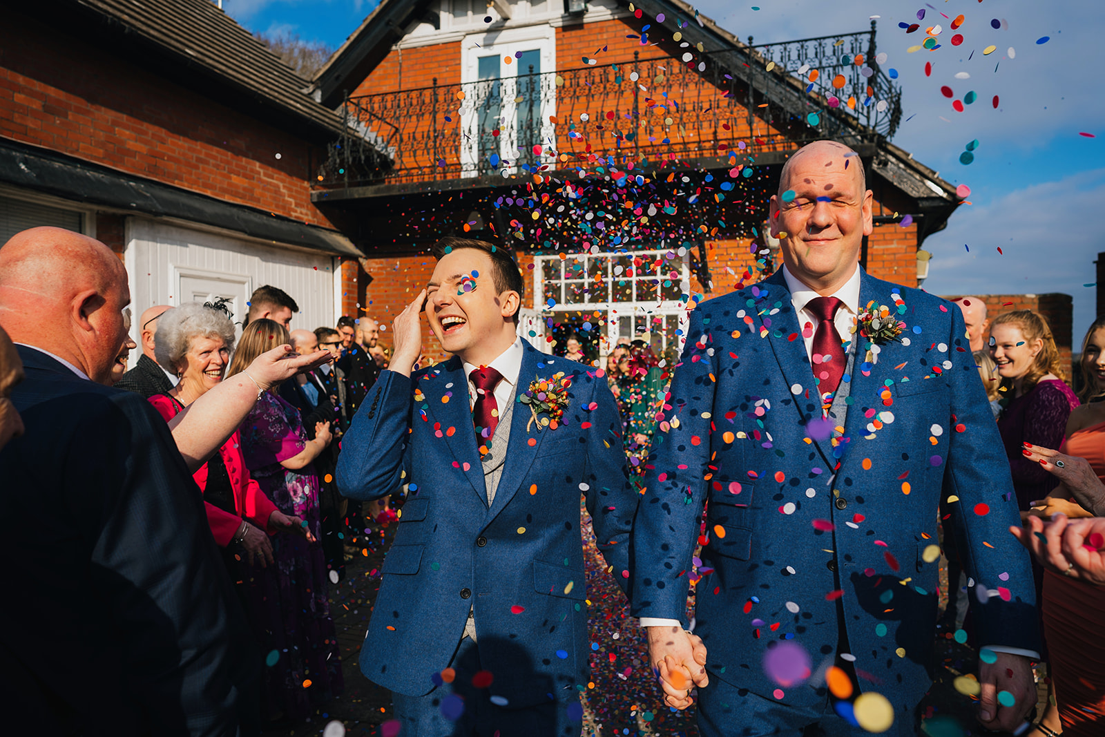rainbow coloured confetti gets thrown over the grooms