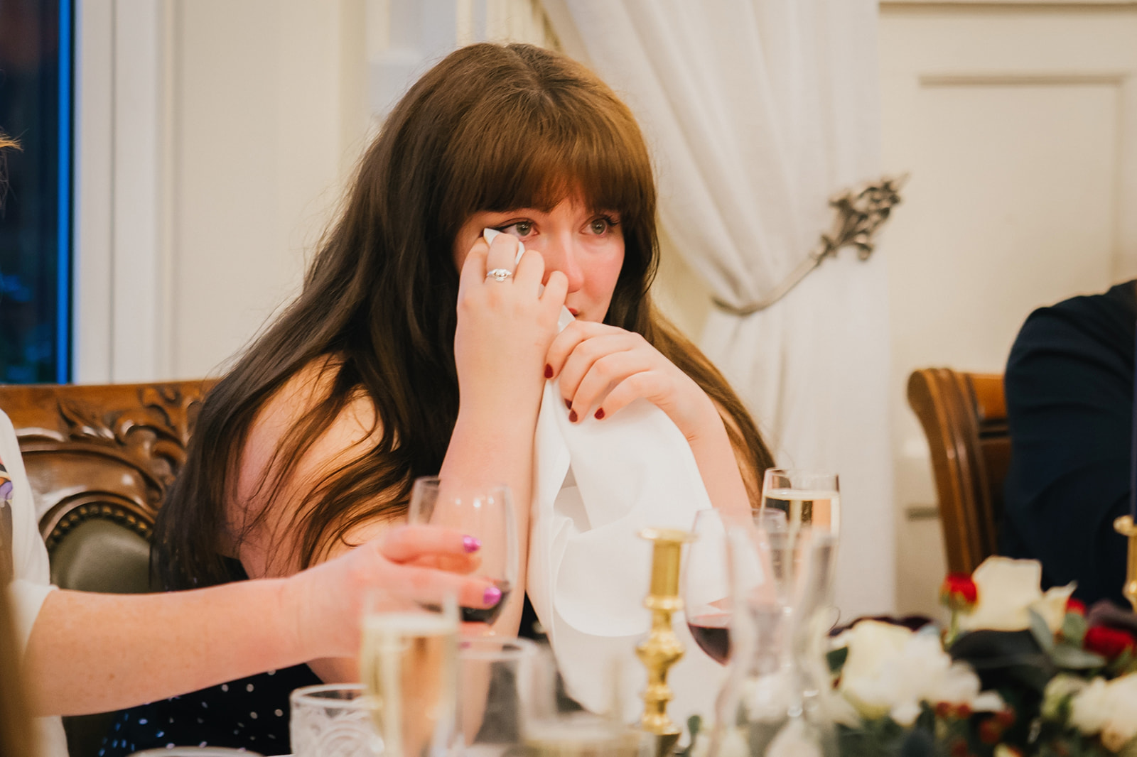 a wedding guest wiping away a tear during the speeches