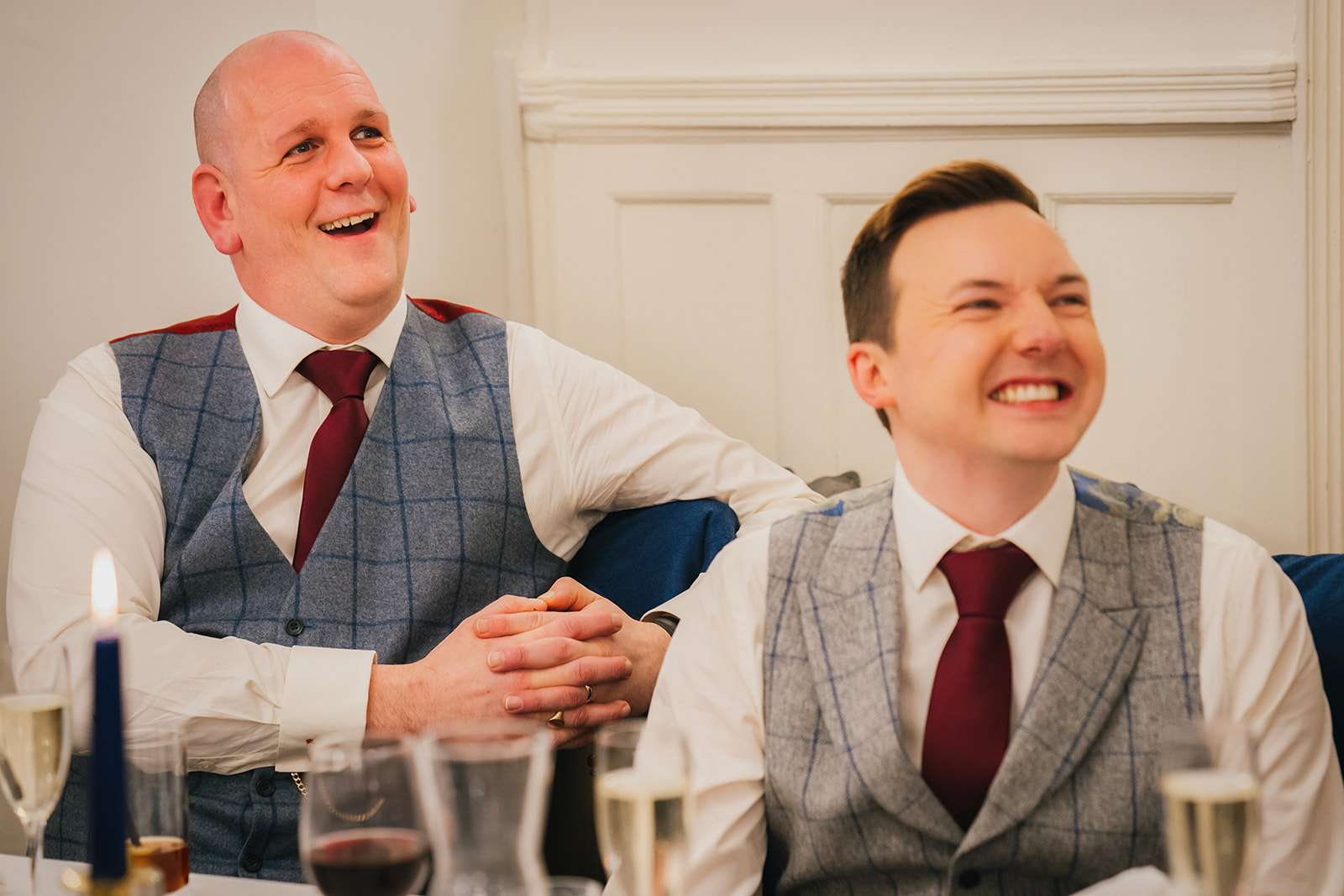 both grooms laughing at the wedding speech