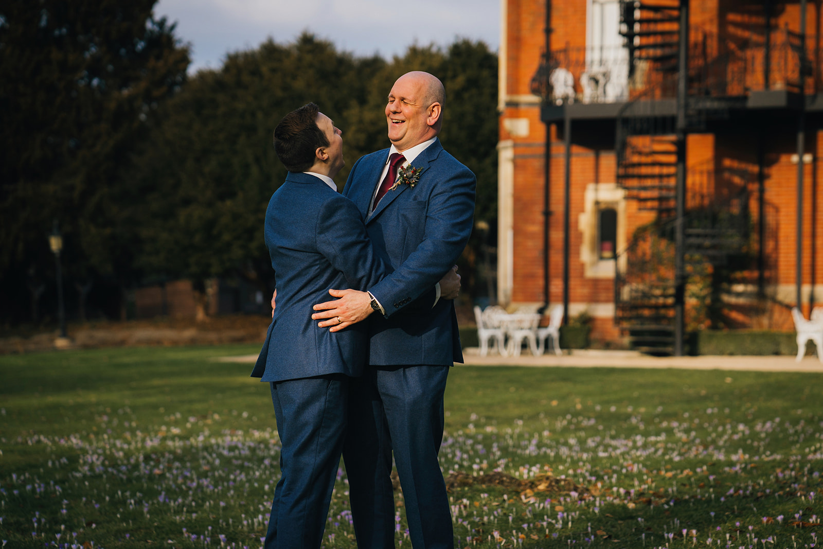 newly wed portrait of the two grooms as they hold one another and laugh