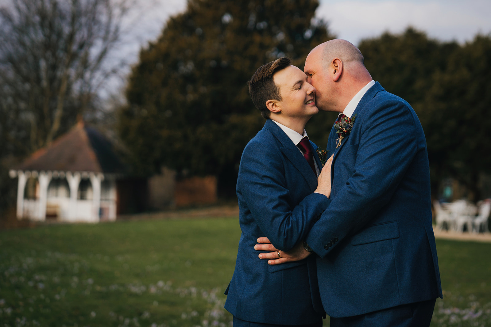 the groom kisses his husband on the cheek