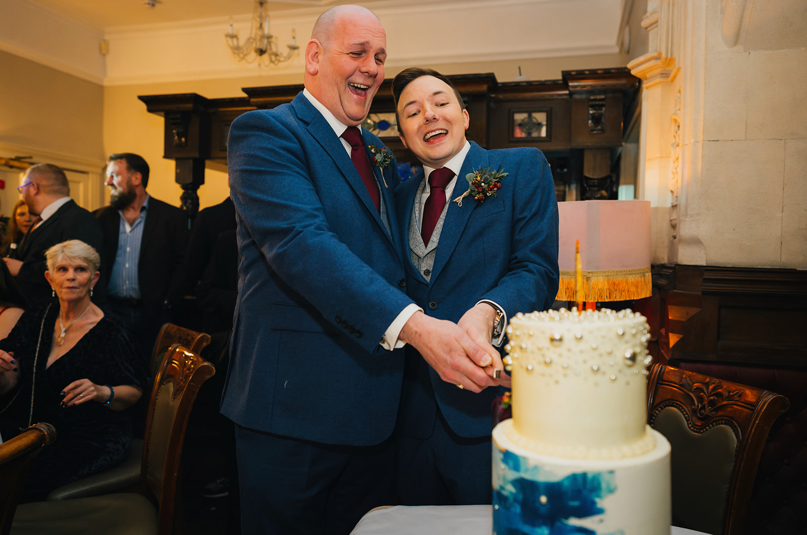 the two grooms cut a wedding cake
