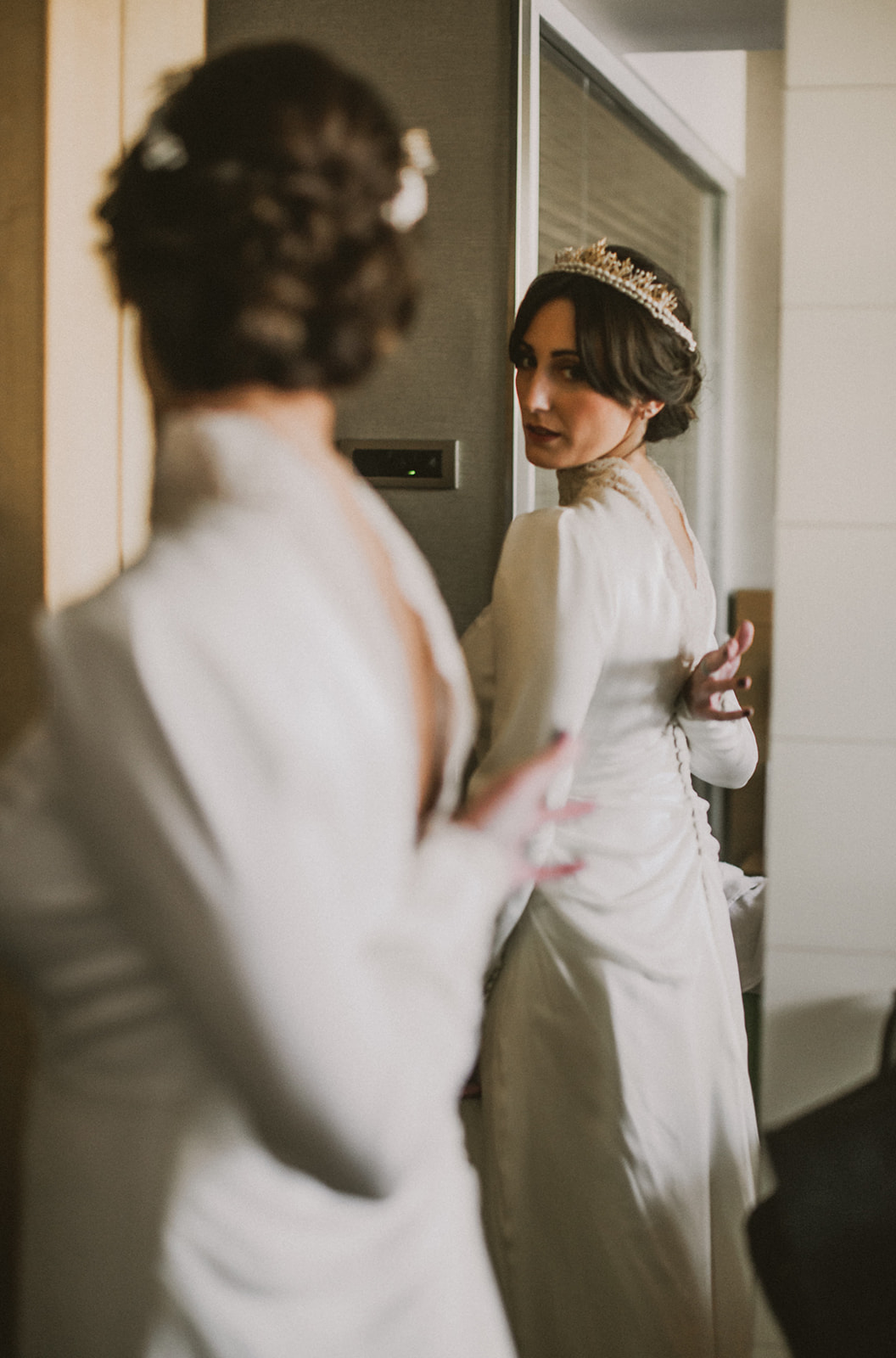 novia preparada para casarse mirándose en el espejo