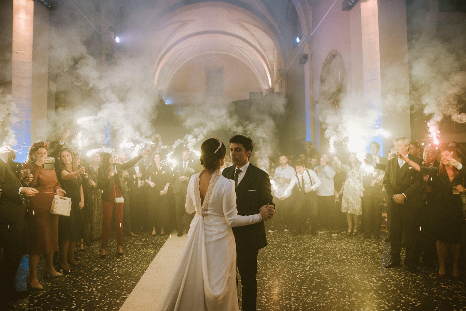 pareja bailando el día de su boda con bengalas de fondo