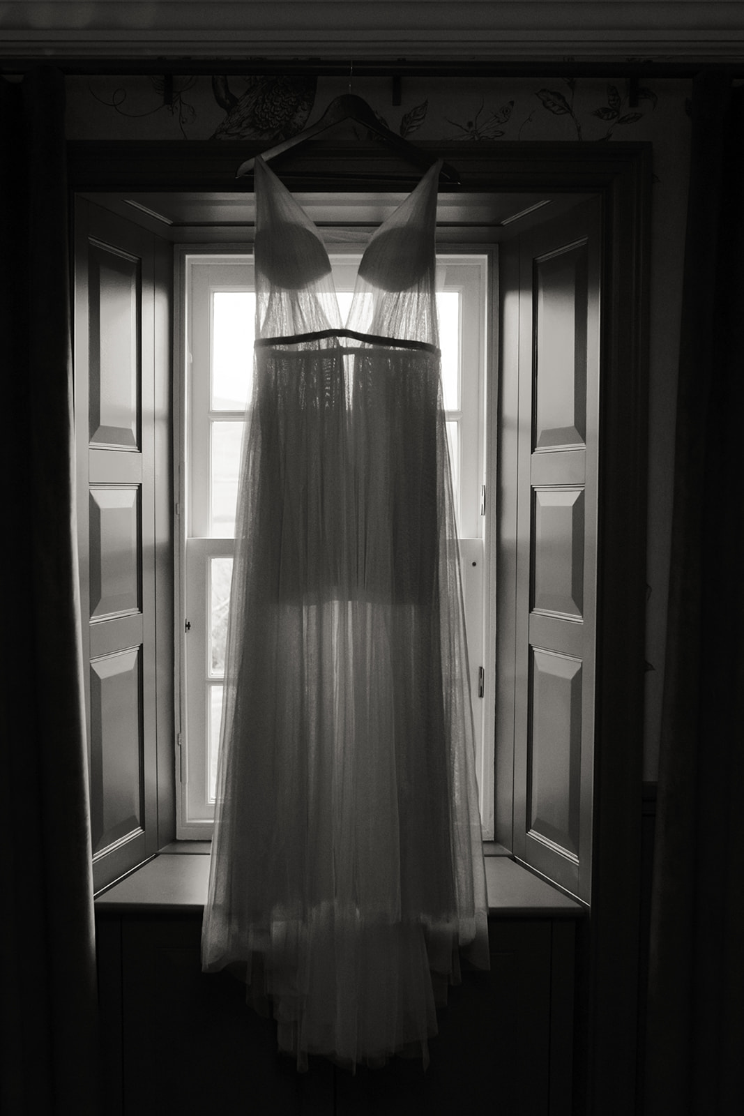 Elopement dress hanging in a window