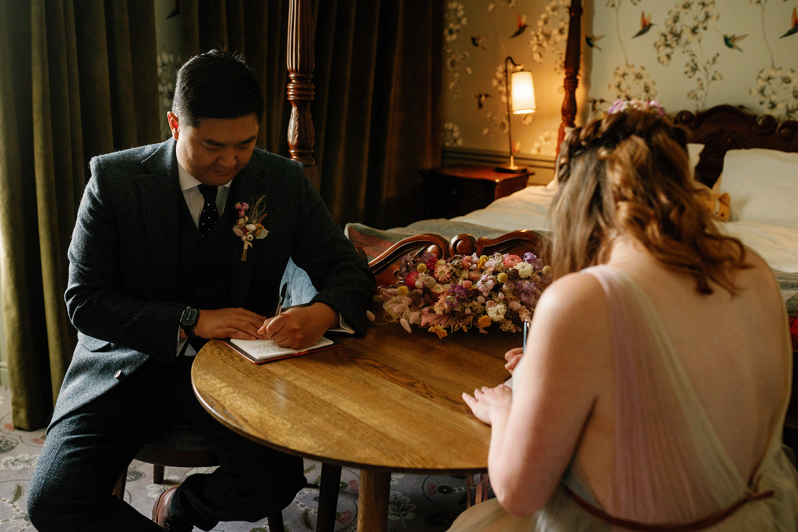 Mellie and Andrew sitting together with their pen and paper, writing their vows for their elopement at the Isle of Skye