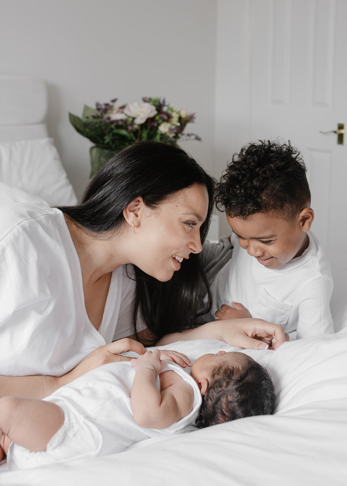 mum and sons talking and smiling during a newborn baby photography 
