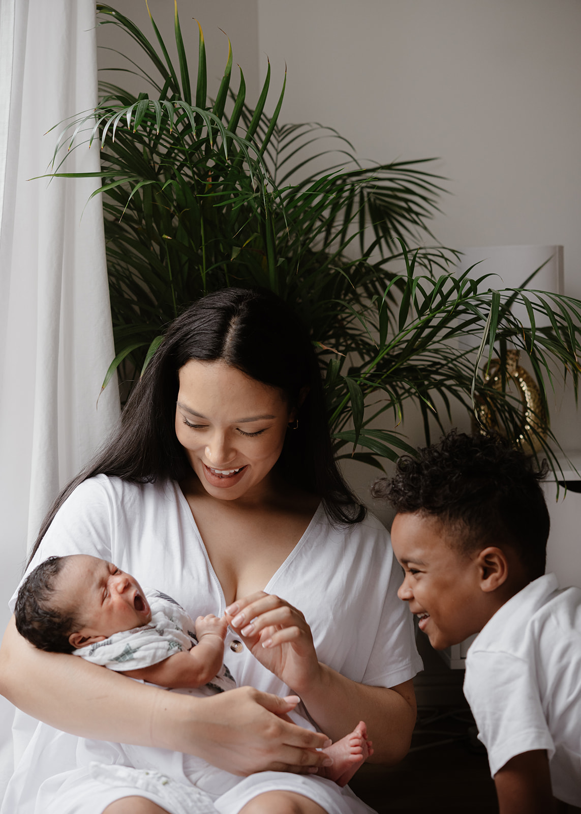 mum and sons smiling and cuddling during a natural newborn baby photography by agi lebiedz