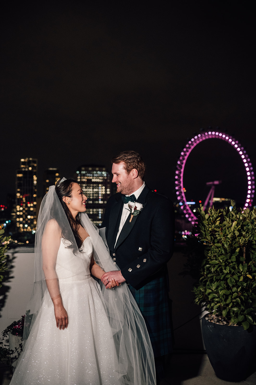 Bride and Groom on the roof of Corinthia Hotel with views of the London skyline behind.