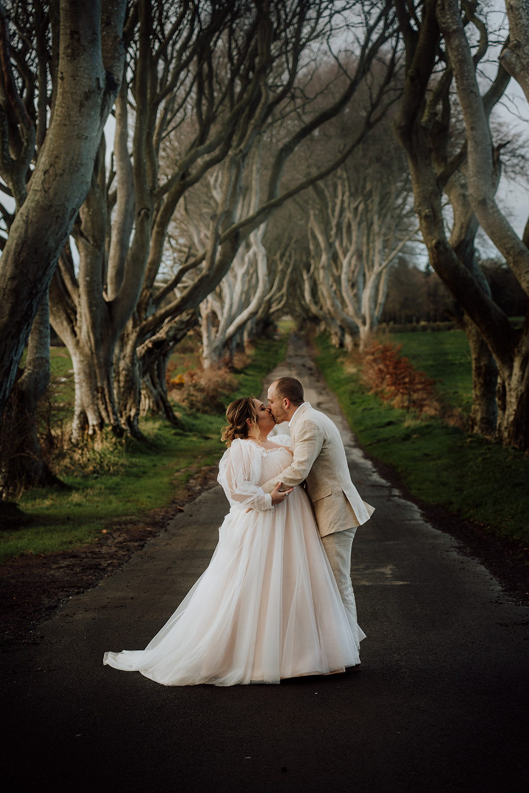 couple looking at each other lovingly along dark hedges trees kings road 