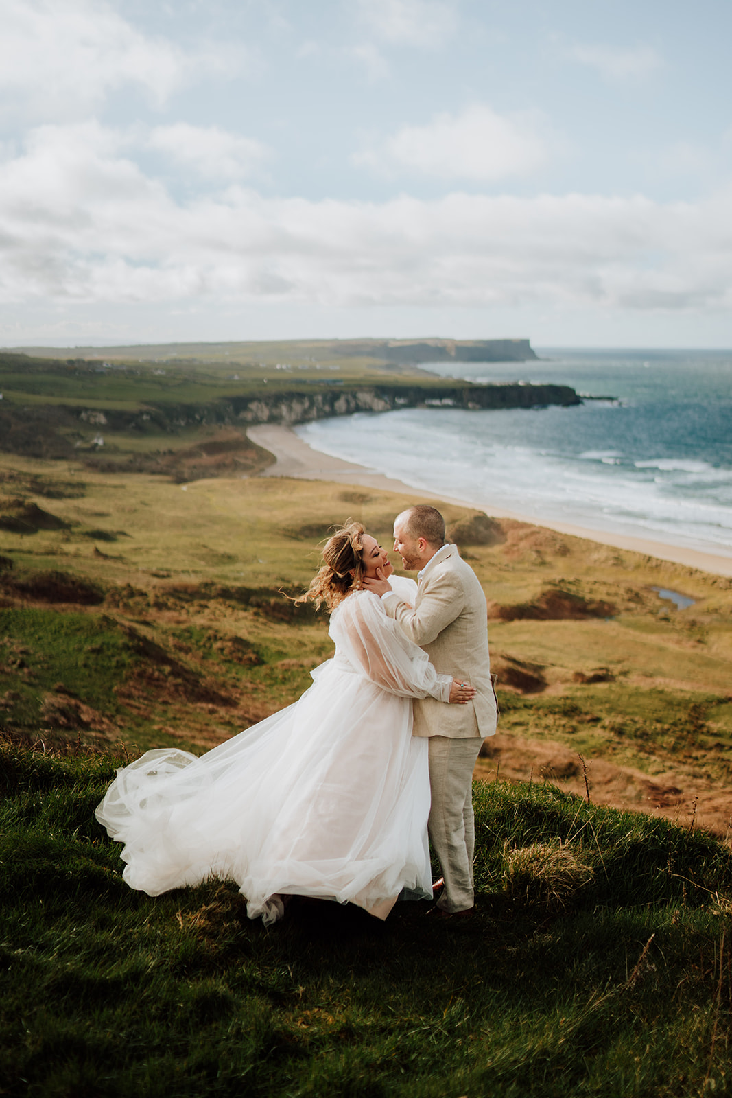 couple looking at each other overlooking whitepark bay and epic irish scenery