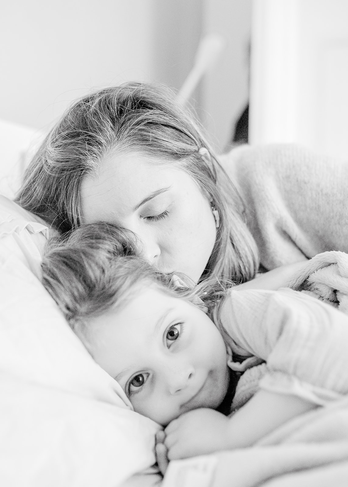 mum and daughter in a cuddle in bed during the natural maternity photography by agi lebiedz