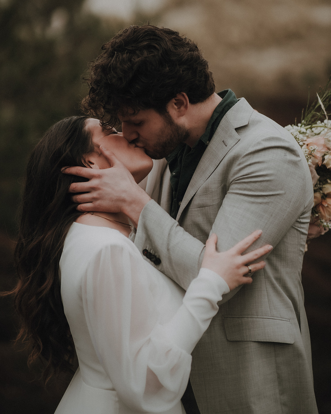 Wedding couple kissing in the rain surrounded by dunes