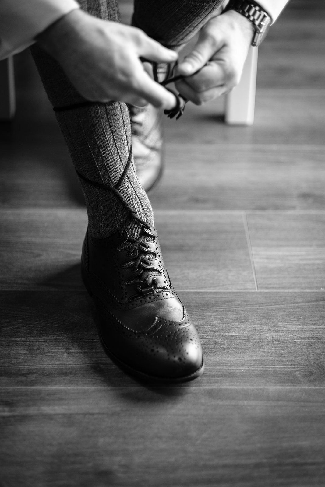 Close up of groom tying his shoelaces