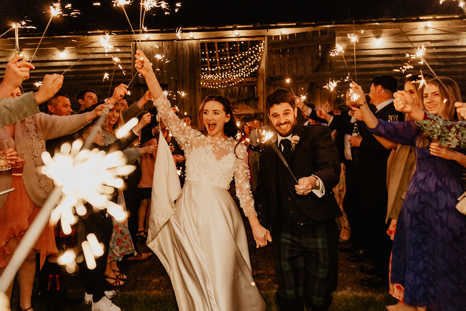 Bride and groom under sparklers at a Secret Barn Wedding, West Sussex. By Olive Joy Photography