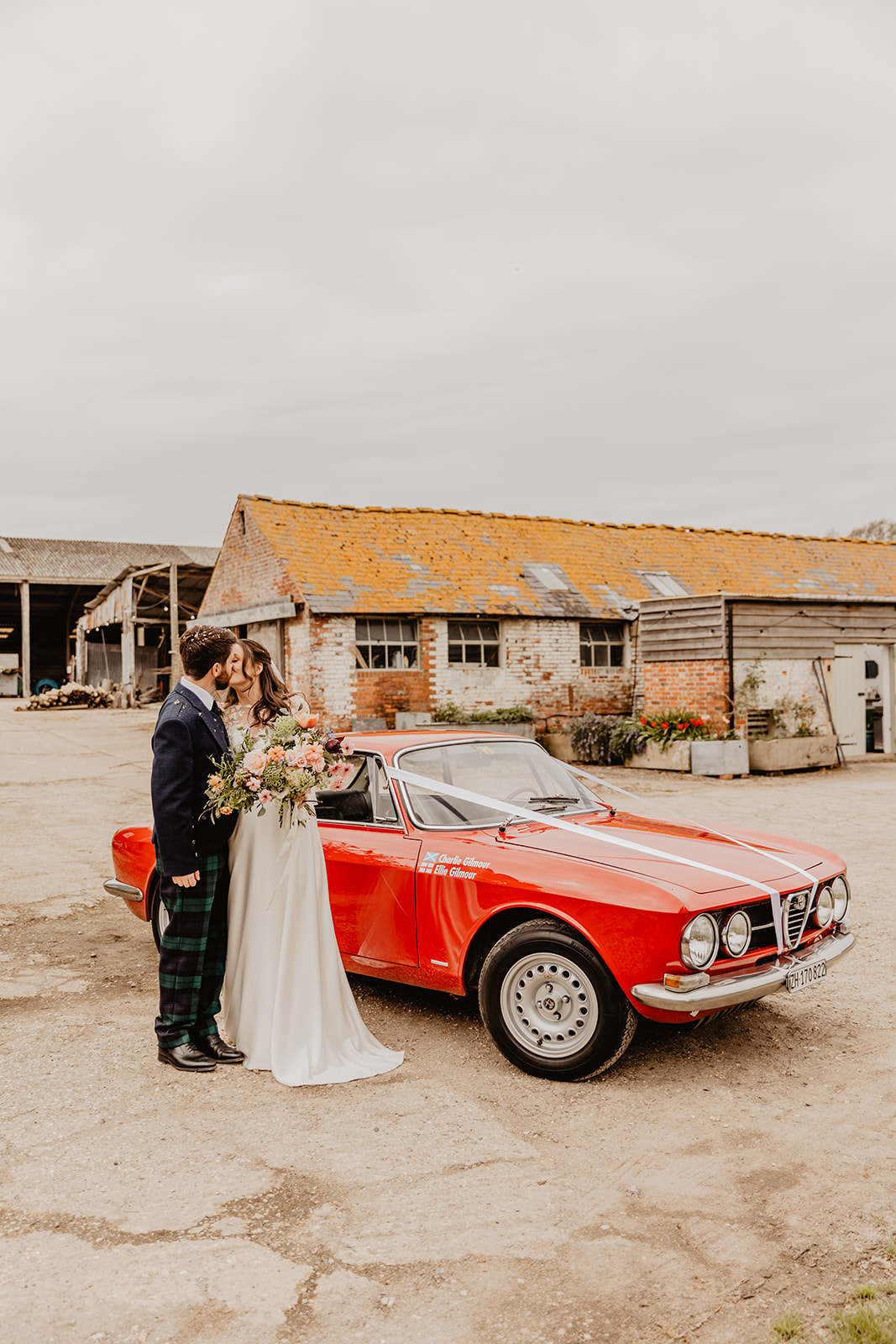 Bride and Groom by wedding car a Secret Barn Wedding, West Sussex. By Olive Joy Photography
