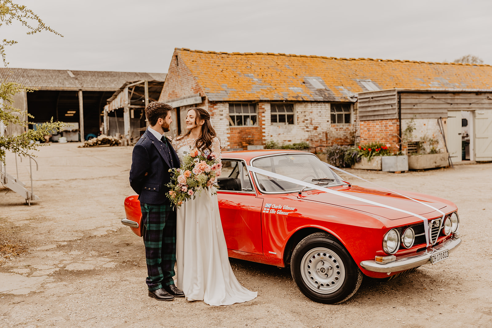 Bride and Groom by wedding car a Secret Barn Wedding, West Sussex. By Olive Joy Photography