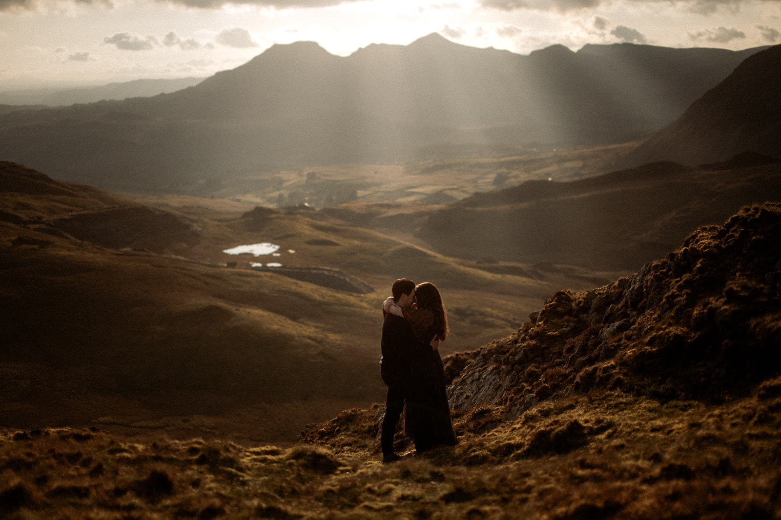 A couple enjoying their pre-wedding photography adventure at sunset in Snowdonia.