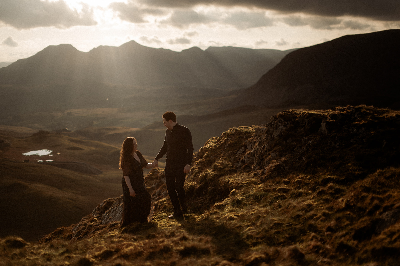 A couple enjoying their pre-wedding photography adventure at sunset in Snowdonia.