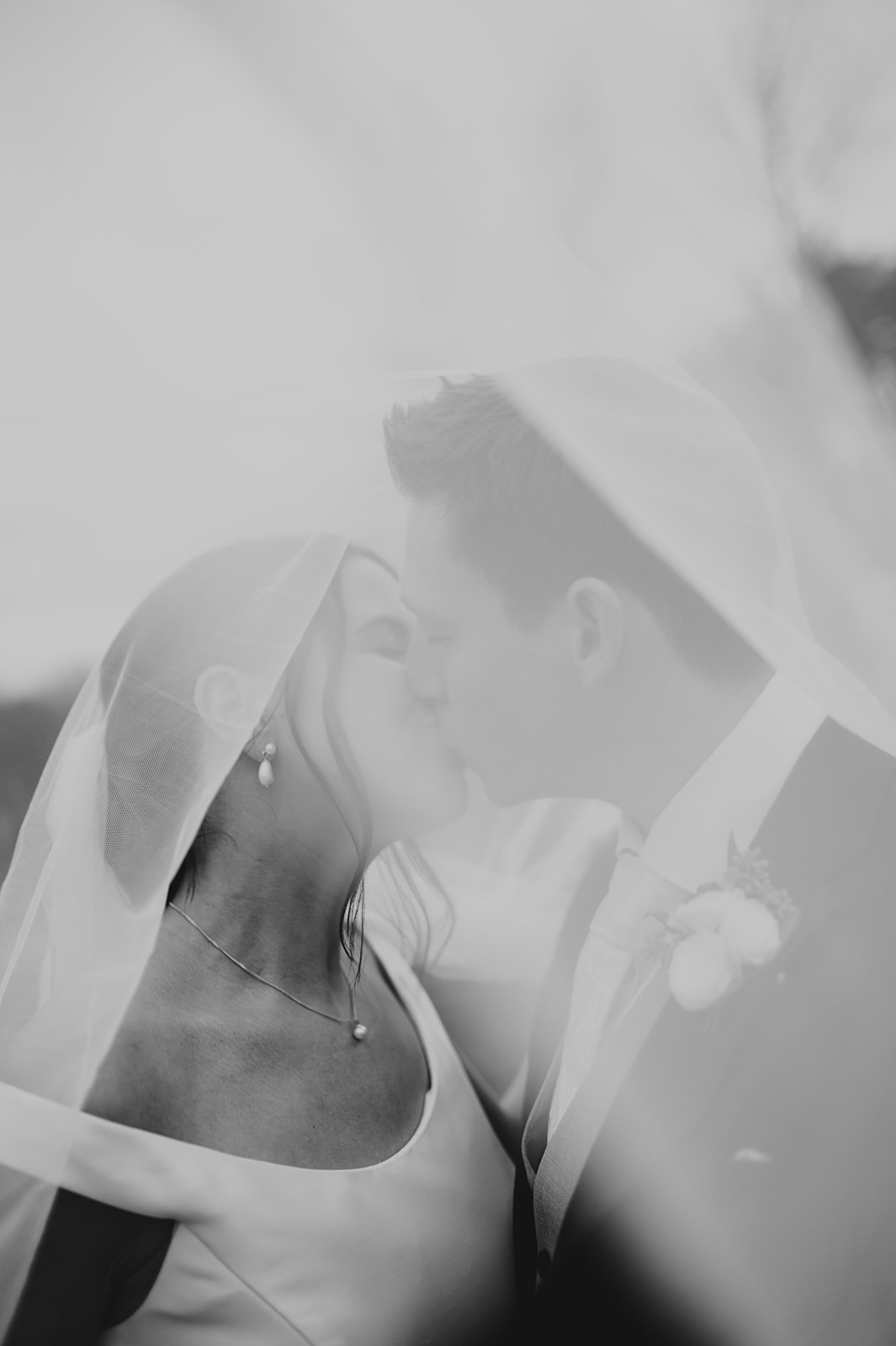 black and white bride and groom kissing under veil at upwaltham barn autumn wedding 