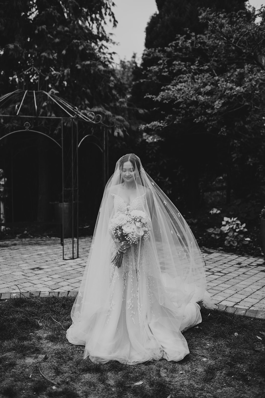 black and white of bride standing under long veil at Pelham house wedding