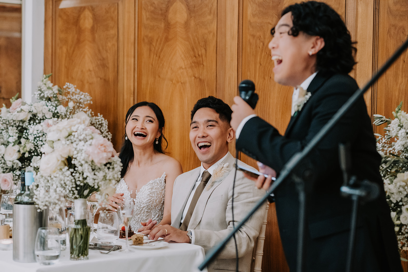 bride and groom laughing during best mans speech at Pelham house summer wedding 