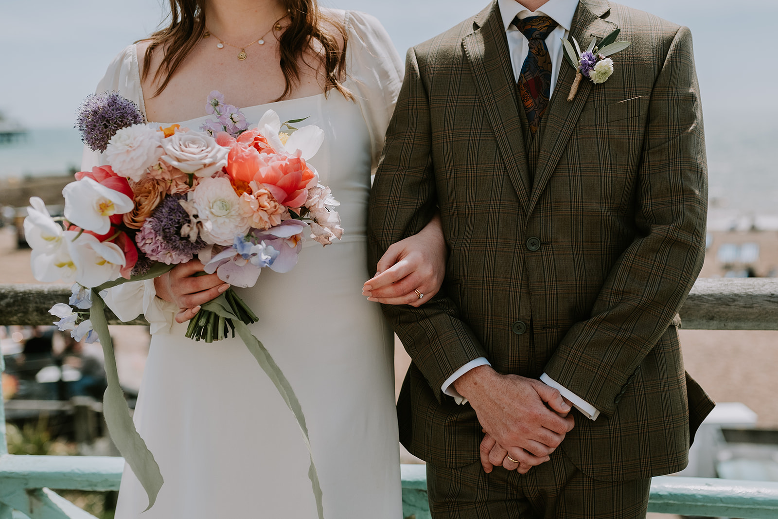 bride and groom linking arms with peony bouquet at brighton wedding 