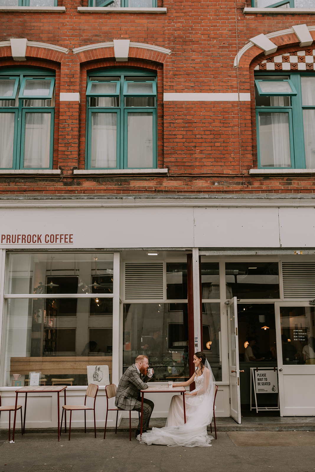bride and groom sat outside prufrock cafe drinking coffee in summer London wedding 