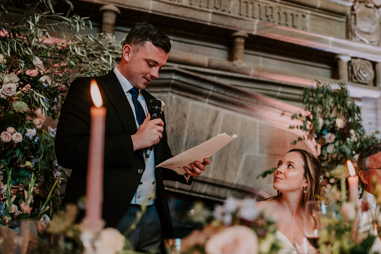 bride smiling at groom whilst giving speech at cowdray house summer wedding 