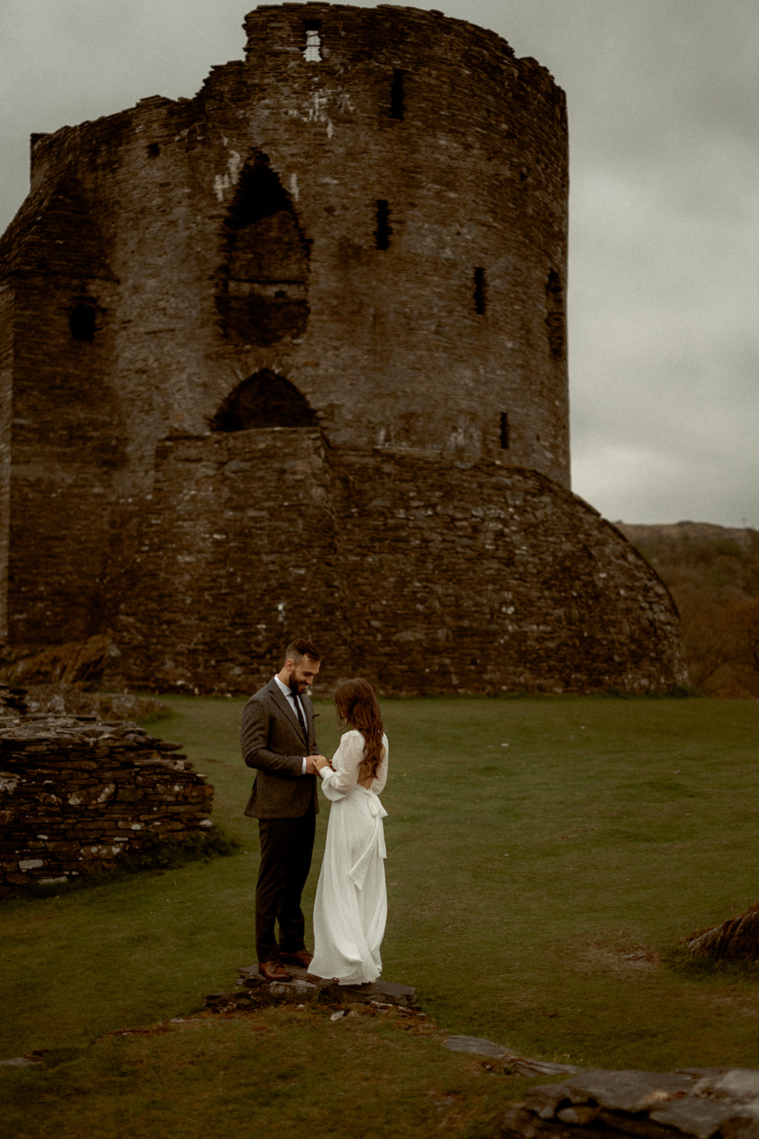 a couple from Canada in front of a castle in Wales on their elopement-style wedding day.
