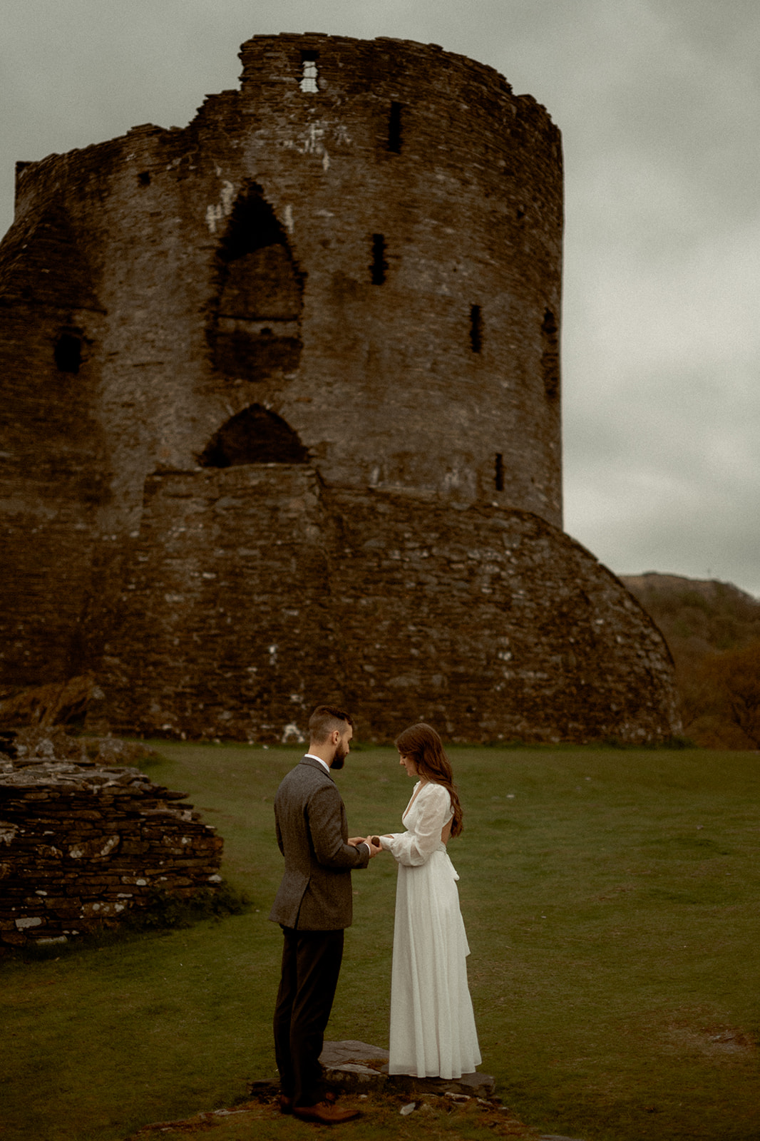 a couple from Canada in front of a castle in Wales on their elopement-style wedding day.
