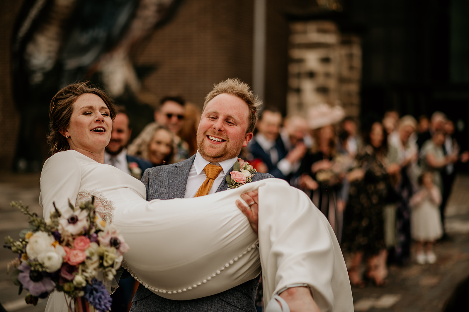 groom carrying bride confetti in Derby