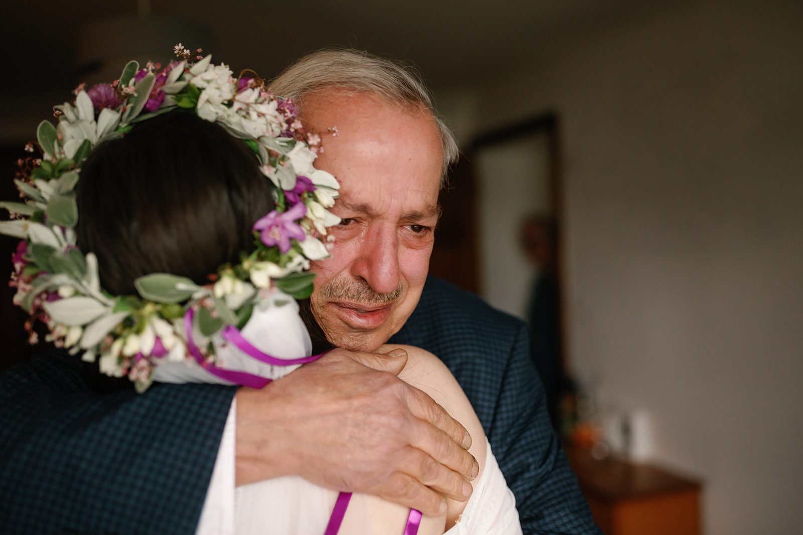 Bride Becca, emotionally embraced by her father, shares a first look moment during their Isle of elopement day