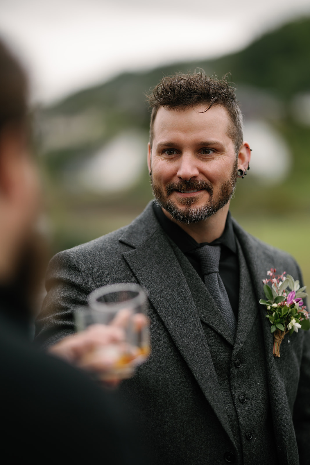 Groom Nick, flanked by his best man and officiant Wes, shares a dram of local Skye whisky, Talisker