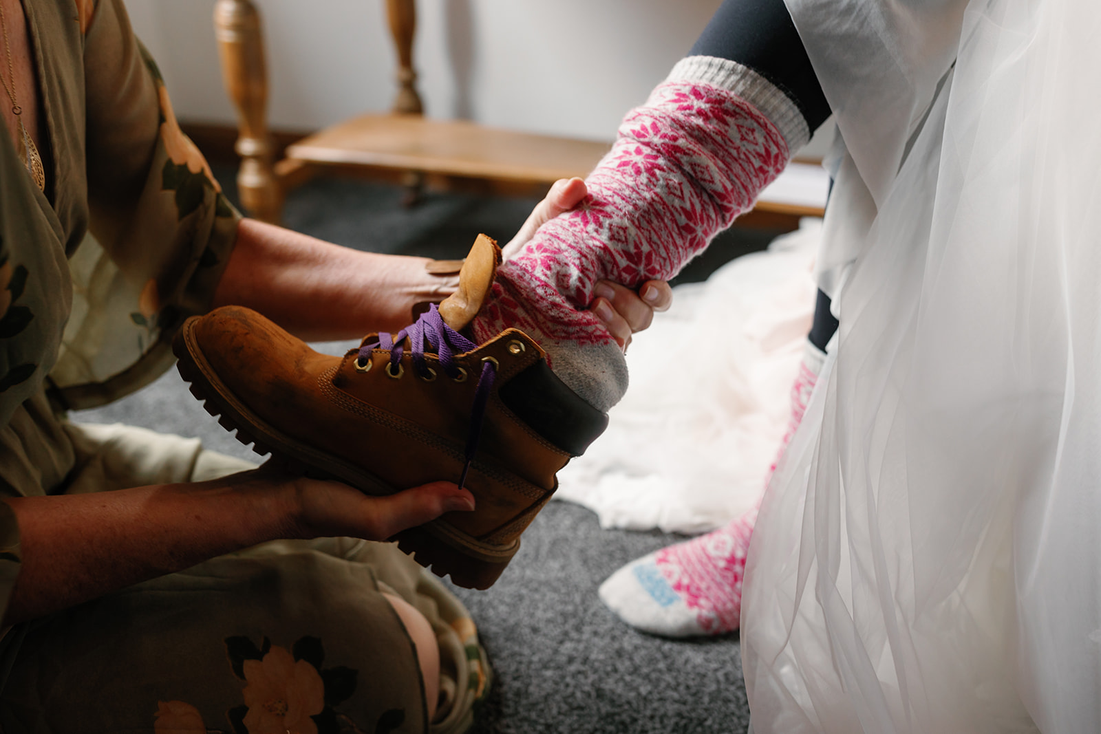 Becca's mother helps her with her boots, a cherished moment before her Isle of Skye elopement ceremony 