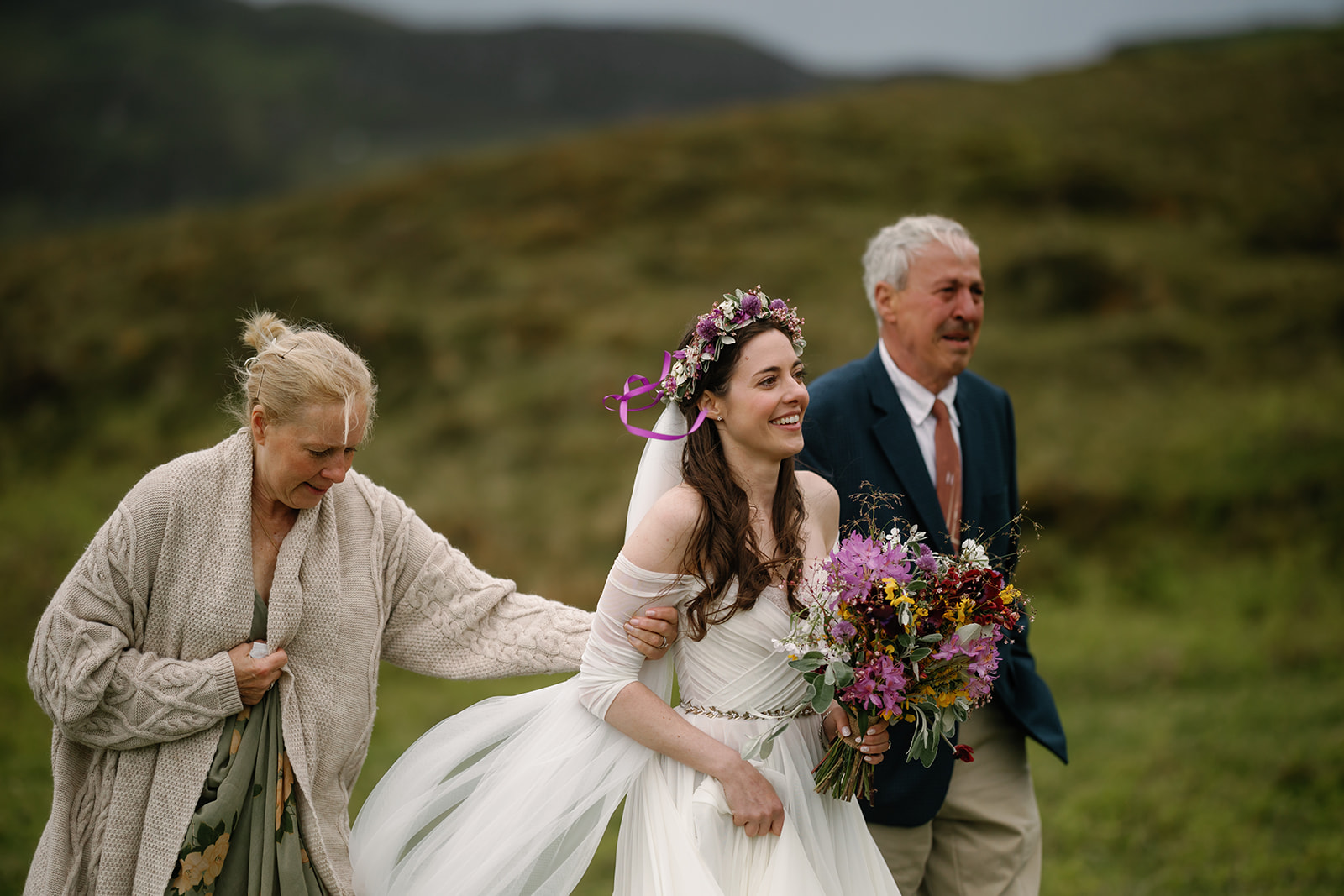 Becca and her parents, accompanied by the melodic notes of a bagpipe, walk toward the ceremony spot at the Isle of Skye
