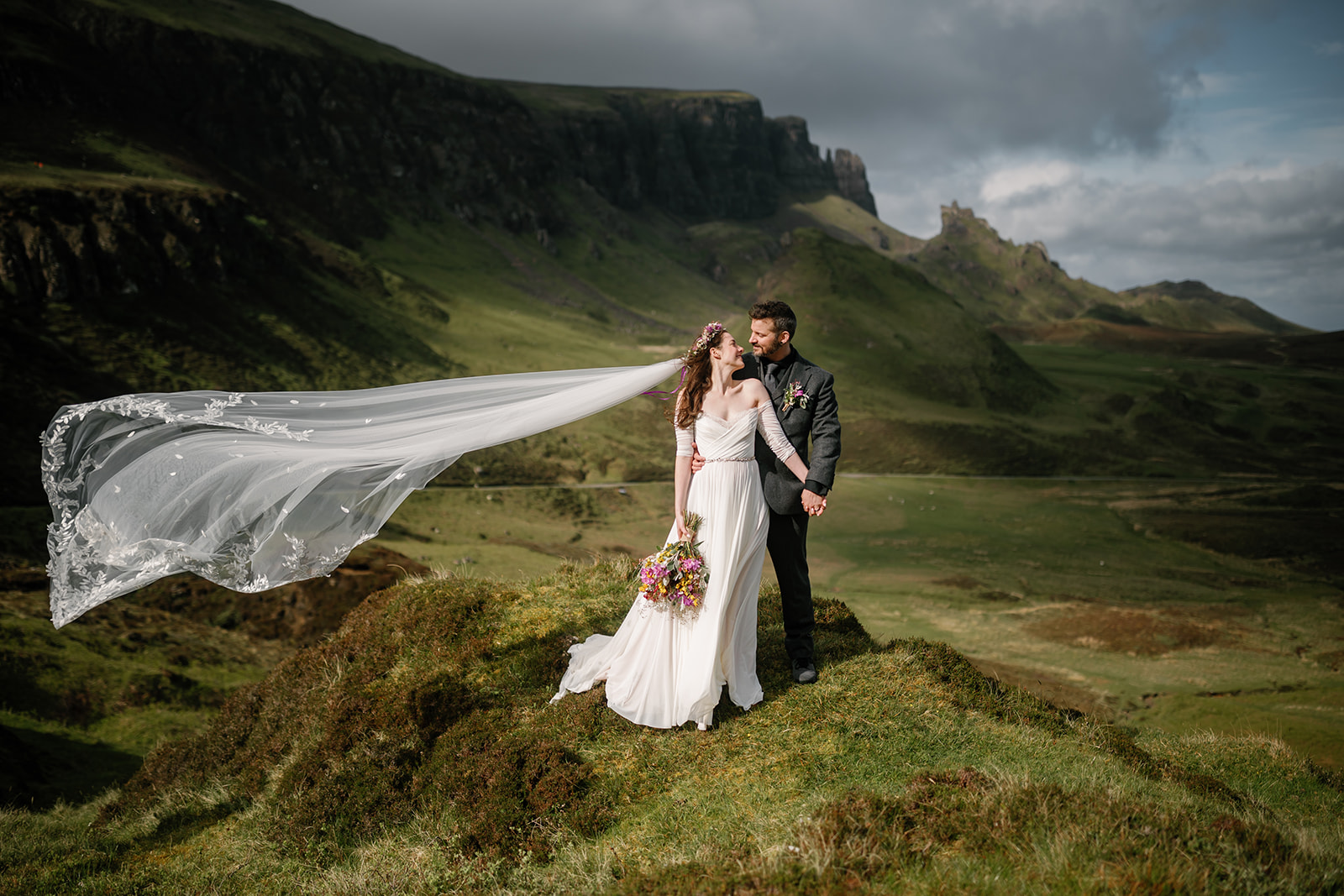 Becca and Nick, framed by the beautiful Quiraing, share a moment of pure joy during their elopement day