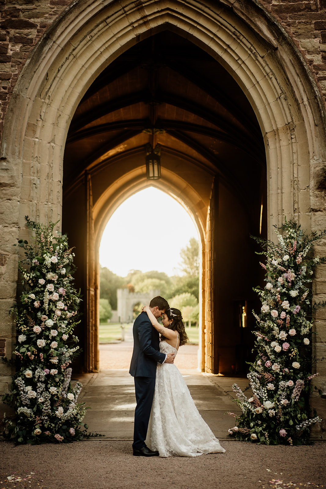 Bride and groom hugging in the entrance to Hampton Court Castle where they had their wedding ceremony