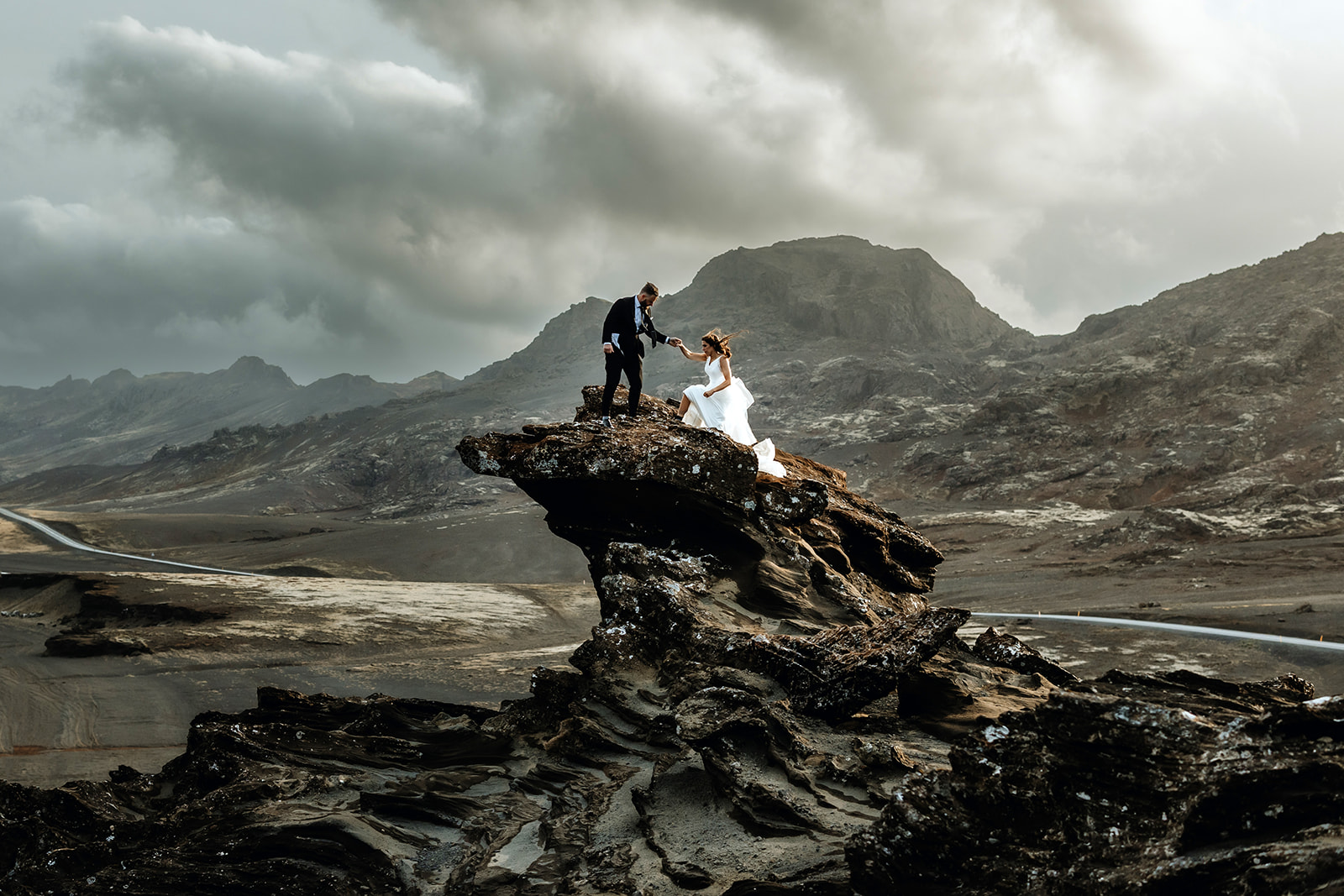 Couple who eloped in Iceland is climbing up on a dramatic cliff