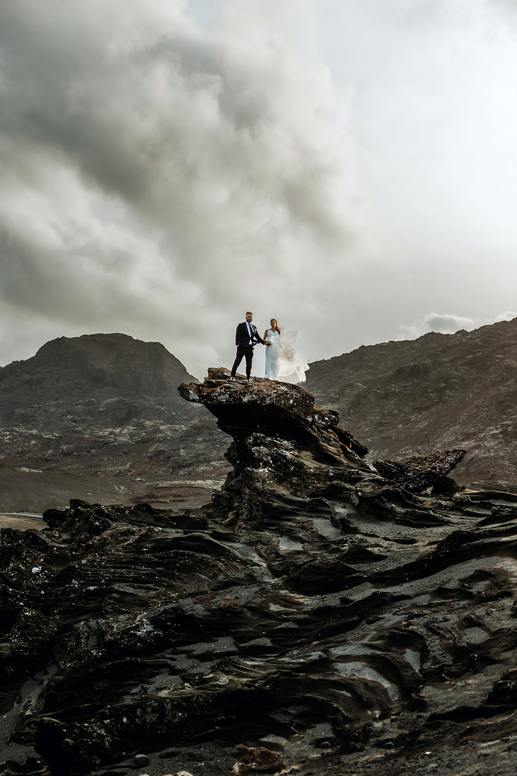 Couple who eloped in Iceland is climbing up on a dramatic cliff