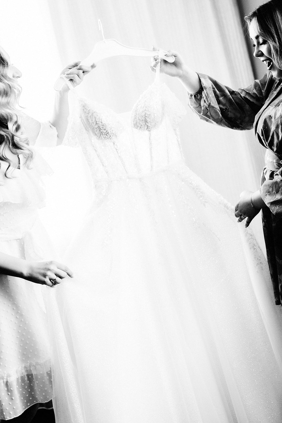 Panna Młoda i świadkowa oglądają suknię ślubną