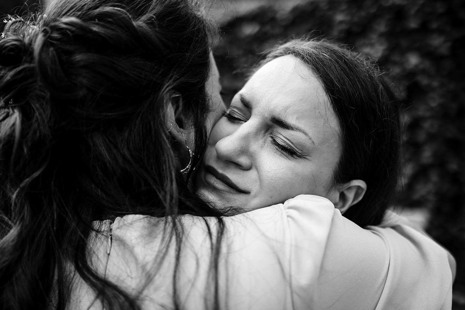 emotionele knuffel tussen bruid en haar zus